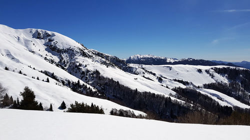 Scenic view of snowcapped mountains against clear sky