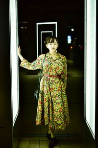 Portrait of woman standing against door