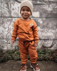 Low section of boy standing on footpath