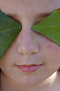 Close-up portrait of young woman with leaves