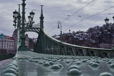 Low angle view of bridge against cloudy sky