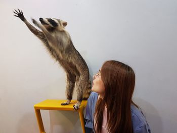 Woman looking at lemur taxidermy on stool