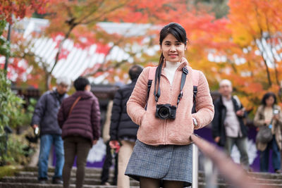 Portrait of young woman standing outdoors during autumn
