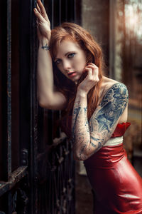 Portrait of beautiful fashion model leaning on metallic gate