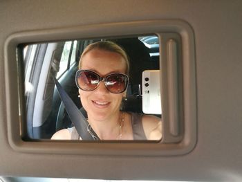 Reflection of woman on mirror in traveling in car