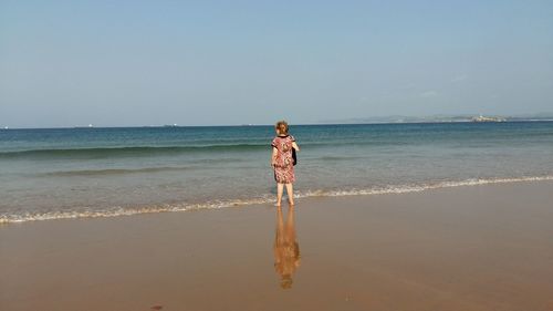Scenic view of calm beach against clear sky