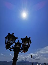 Low angle view of street light against blue sky