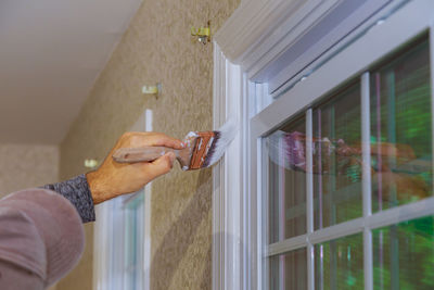 Man holding glass window of house