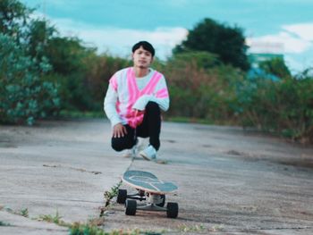 Portrait of young man playing skate on road