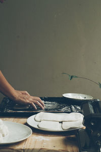 Cropped hands of man preparing food on table