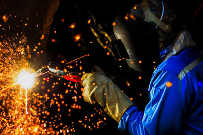 Man welding in workshop at night