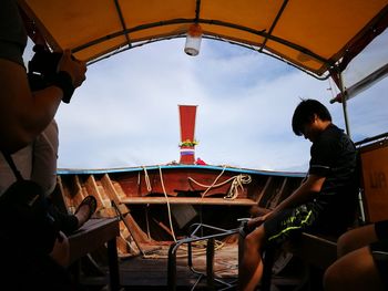 Men in boat against sky