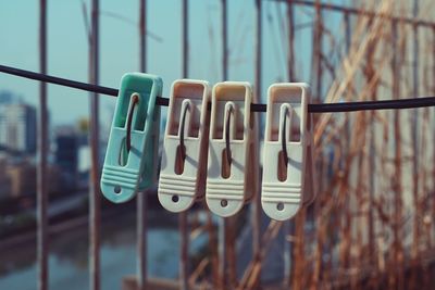 Close-up of clothespin on clothesline by fence