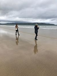 Full length of women at beach against sky