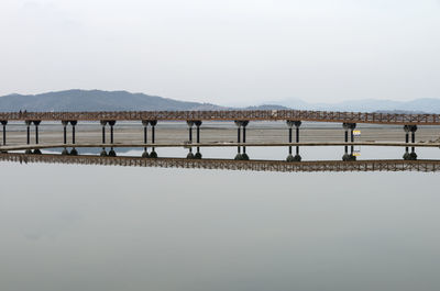 Bridge over sea against clear sky