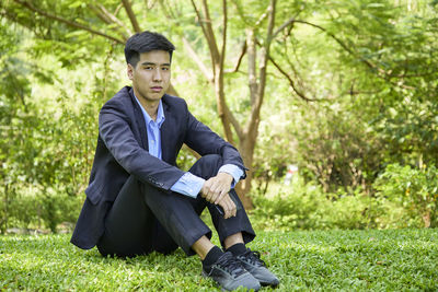 Portrait of young man sitting on land