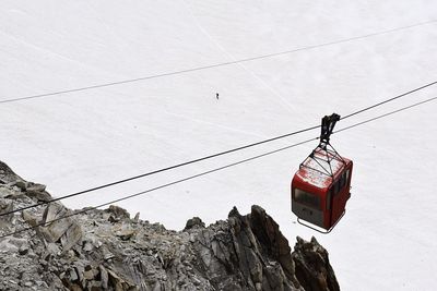 Low angle view of overhead cable car against sky