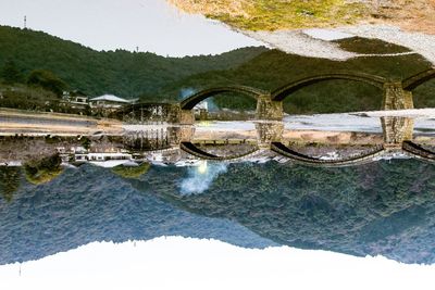 Reflection of tree on mountain against sky