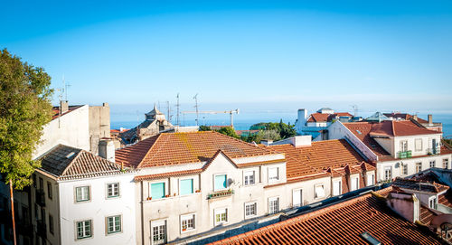 Houses in town against clear blue sky