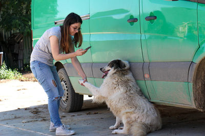 Young woman with dog standing outdoors