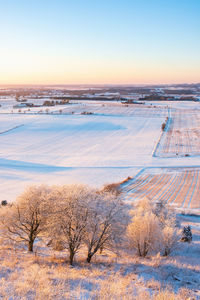 Scenic view of snow field against sky during sunset