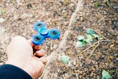 Fidget spinner on man hand outdoors