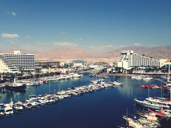 Boats in harbor with cityscape in background