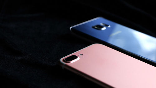 High angle view of smart phones against black background