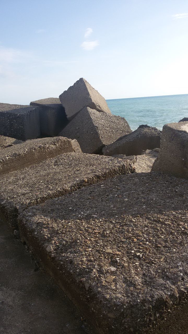 STACK OF ROCKS ON SHORE AT BEACH AGAINST SKY