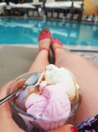 Woman holding ice cream in swimming pool