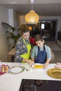 Mother and son making croquettes in the kitchen