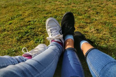 Low section of friends sitting on grass