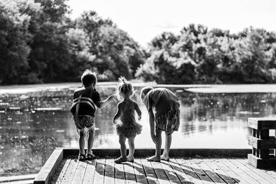 Rear view of children standing by lake