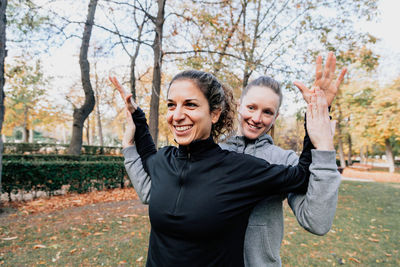 Smiling women exercising in park