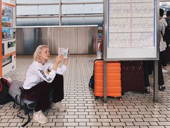 Full length of woman sitting on seat