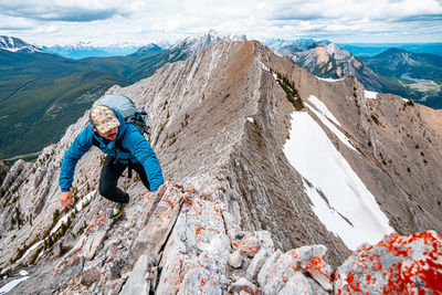 Full length of man standing on rock against sky