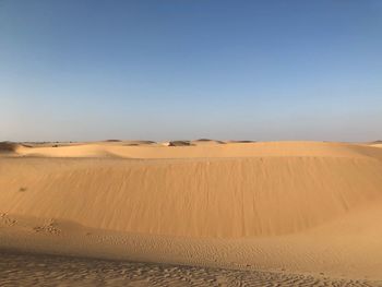 Scenic view of desert against clear blue sky