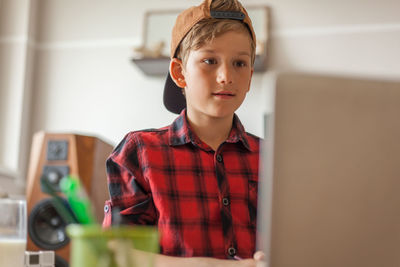 Digital native student e-learning over laptop during coronavirus pandemic at home.