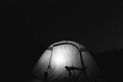 Illuminated tent against dark background