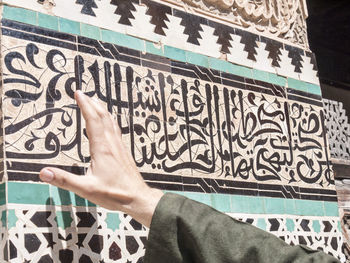 Cropped image of hand touching wall in mosque