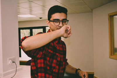 Portrait of man standing against wall