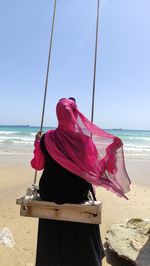 Low angle view of woman standing against clear sky