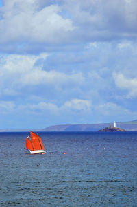 Sailboat in sea against sky