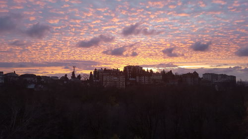 Silhouette buildings against sky during sunset