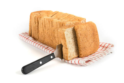 Close-up of bread on cutting board against white background