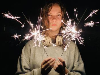 Teen girl with sparklers at night