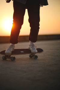 Low section of man skateboarding on beach