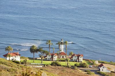 High angle view of houses by sea against sky