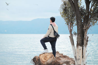 Man standing by sea against sky