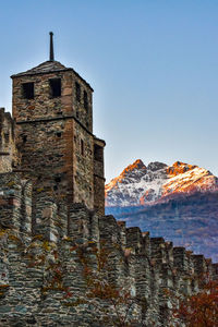 Castle tower and mountain against clear sky 